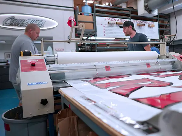 CG Detroit production staff laminating a printed graphic