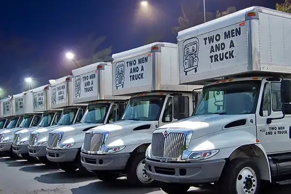 Two Men And A Truck branded fleet at night